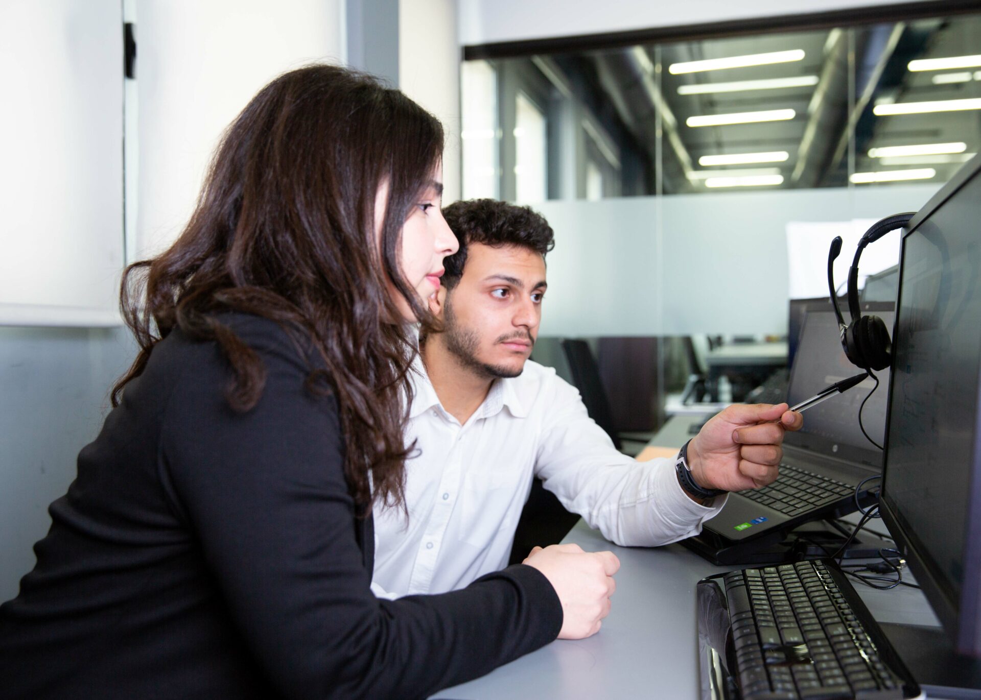 Startup team members pointing at screen at Infoquests office in Dubai